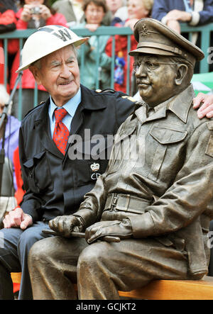 Bill Pertwee, der in der klassischen TV-Komödie Dad's Army spielte, sitzt neben der Bronzestatue von Capatin Mainwaring, gespielt von Schauspieler Arthur Lowe, nachdem sie heute Nachmittag im Stadtzentrum von Thetford Norfolk enthüllt wurde. Stockfoto