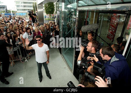 X-Factor Richter Simon Cowell winkt Fans vor dem Dublin Convention Center zu. Stockfoto