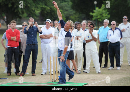 Der australische Cricketspieler Shane Warne demonstriert seine Bowling-Show im Bank of England Sports Center in Roehampton, London, wo Geschäftsleute und sportliche Prominente an einem Fundraising-Cricket-Spiel für die Kinderhilfe Operation Smile teilnahmen. Stockfoto