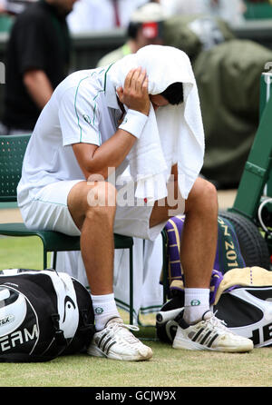Serbiens Novak Djokovic sitzt niedergeschlagen, nachdem Umpire Carlos Ramos gibt Er hat einen Code verletzt, weil er mit seinem auf seinen Stuhl geschlagen hat Schläger während des Halbfinalmatches der Herren gegen die Tschechische Republik Tomas Berdych Stockfoto