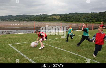 Kinder nehmen an Street Rugby on the Green in Lochgoilhead, Schottland, Teil. Stockfoto