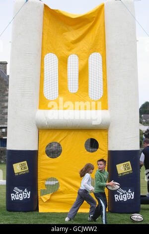 Kinder nehmen an Street Rugby on the Green in Lochgoilhead, Schottland, Teil. Stockfoto