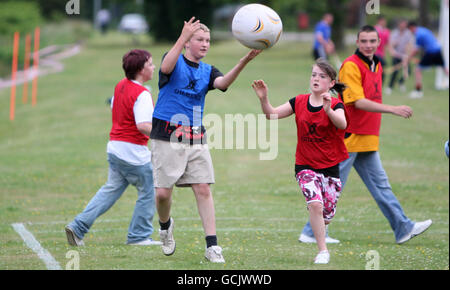 Kinder nehmen an Street Rugby on the Green in Lochgoilhead, Schottland, Teil. Stockfoto