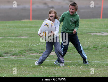 Kinder nehmen an Street Rugby on the Green in Lochgoilhead, Schottland, Teil. Stockfoto