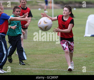 Kinder nehmen an Street Rugby on the Green in Lochgoilhead, Schottland, Teil. Stockfoto