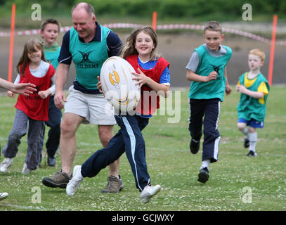 Kinder nehmen an Street Rugby on the Green in Lochgoilhead, Schottland, Teil. Stockfoto