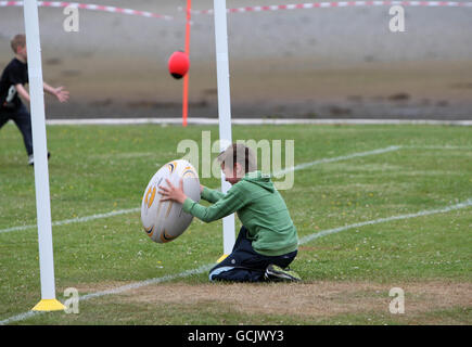 Kinder nehmen an Street Rugby on the Green in Lochgoilhead, Schottland, Teil. Stockfoto