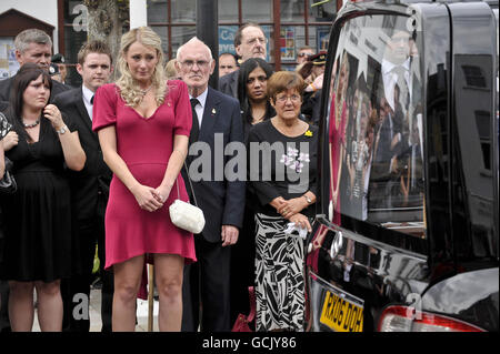 Heidi Kirkpatrick (im rosa Kleid), die Frau von Corporal Jamie Kirkpatrick, 32, vom 101 Engineer Regiment, sieht zu, wie der Sarg ihres Mannes entlang der High Street in Wootton Bassett, Wiltshire, gefahren wird. Stockfoto