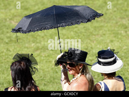 Weibliche Rennfahrerinnen schützen sich während des July Festivals auf der Newmarket Racecourse, Newmarket. Stockfoto