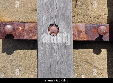 Abstrakte Closeup rustikal und verwitterten Bank Materialien im Kreuz Form mit Holzbrett und rostige Metallstreben. Stockfoto