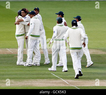 Pakistans Umar Gul (zweiter links) feiert, dass er beim ersten Testspiel auf dem Lord's Cricket Ground, London, das Dickicht von Australiens Michael Clarke mit seinen Teamkollegen übernimmt. Stockfoto