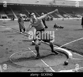 Kenneth MacDonald, der das Gewicht (Schuss) während der Vorrunden bei den London Caledonian Games in White City. Stockfoto