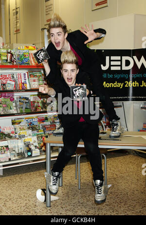 John und Edward (top) Grimes, besser bekannt als Jedward, während einer ersten Signaturstunde für ihr Album, im Tesco Extra in Brent Park, Wembley, Nord-London. Stockfoto