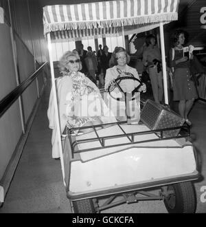 Schauspielerin Zsa Zsa Gabor in einem Airline-Buggy, als sie an Bord eines Flugzeugs nach Chicago am Flughafen Heathrow geht. Stockfoto