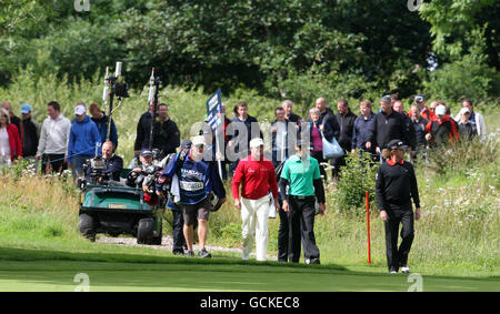 Am ersten Tag der Barclays Scottish Open im Loch Lomond Golf Club, Loch Lomond, folgen Menschenmassen dem nordirischen Graeme McDowell, dem südafrikanischen Charl Schwartzel und dem spanischen Miguel Angel Jimenez (links nach rechts). Stockfoto