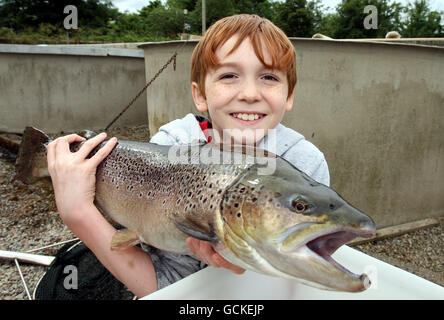 Daniel Faith, 10, bekommt eine große Braune Forelle am River Bush Salmon Station Open Day, in Bushmills Co Antrim zu halten. Die Öffentlichkeit wurde durch die Station geführt, wo sie die Brutstätte und die Fischaufzuchtanlage sowie Lachs in verschiedenen Entwicklungsstadien sahen. Stockfoto