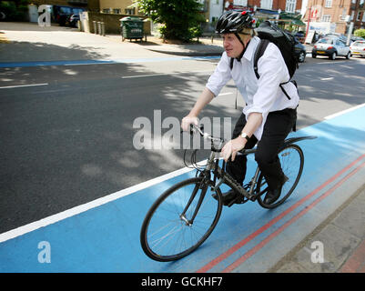 Der Bürgermeister von London, Boris Johnson, fährt mit seinem Fahrrad in der Nähe von Clapham Common im Südwesten Londons, während der Eröffnung eines der neuen Cycle Superhighways. Stockfoto