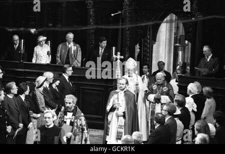 Der Erzbischof von Canterbury, Dr. Robert Runcie, begleitet von Papst Johannes Paul II., während der Zeremonie in der Kathedrale von Canterbury. Die Prince of Wales Uhren, oberster Vierter von links. Stockfoto