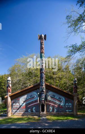 Totempfähle vor einem großen Clan Haus gemalt mit Bildern von den Raben Totem Bight Historic State Park, Ketchikan, südöstlichen Alaska, USA, Frühling Stockfoto