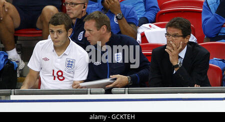 Der englische Trainer Stuart Pearce (C) gibt Jack Wilshere Anweisungen (L) vor seinem England-Debüt als Manager Fabio Capello (R) Schaut das Spiel an Stockfoto