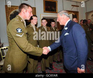 Der Prinz von Wales (rechts) spricht mit Lance Corporal Rob Farkins, 20, nachdem er unerwartet zu einem Empfang der Herzogin von Cornwall für Veteranen, die Soldaten und Offiziere der 9./12. Lancers im Clarence House im Zentrum von London dienen, kam. Stockfoto