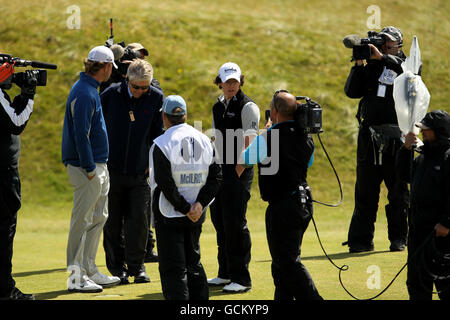 Rory McIlroy (4. Links) aus Nordirland und Lucas Glover aus den USA sehen verblüfft aus, nachdem das Spiel während der zweiten Runde der Open Championship 2010 in St. Andrews, Fife, Schottland, wegen starker Winde ausgesetzt wurde Stockfoto