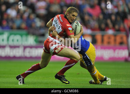 Wigans Sam Tomkins (links) wird von Warrington's Chris Hicks während des Engage Super League Spiels im DW Stadium, Wigan, angegangen. Stockfoto