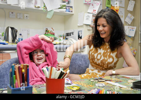 EDITOREN BEACHTEN SIE BITTE BILDUNTERSCHRIFTENKORREKTUR, DIE CATRIN VERDINS HEIMATSTADT ABERAVON IN ABERAERON ÄNDERT. SIEHE KORREKTE BESCHRIFTUNG UNTEN. Catherine Zeta Jones mit Catrin Verdin, sieben Jahre alt, aus Aberaeron im Kinderspielzimmer, bei einem Besuch im Children's Hospital for Wales in Cardiff, wo sie und ihr Mann Michael Douglas Mitarbeiter und Kinder kennenlernten. Stockfoto