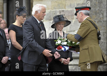 WO2 Pat Hyde von The Rifles präsentiert die Ausrüstung der Mutter und dem Vater von Major Josh Bowman, Jonathan und Barbara Bowman, Die aus der Unionsflagge bestehen, die seinen Sarg, einen Blumenkranz, Joshs Mütze und seine Medaillen nach einem Trauerdienst, der zu seinen Ehren in der Salisbury Cathedral, Wiltshire, abgehalten wurde. Stockfoto