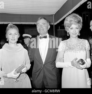 Schauspieler James Mason, Mitte, begleitet die Hollywood-Schauspielerinnen Joanne Woodward, Left, Ehefrau von Paul Newman, und Barbara Rush bei der Premiere seines neuen Films 'Mayerling'. Stockfoto