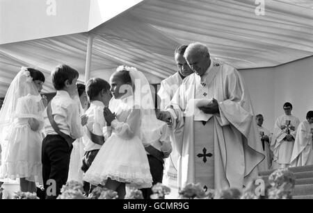 Glasgow-Kinder nahmen am fünften Tag seines historischen Besuchs in Großbritannien ihre erste Heilige Kommunion von Papst Johannes Paul II. Im Bellahouston Park, Glasgow, ein, als er vor einem geschätzten Drittel der schottischen Katholiken die Messe feierte. Stockfoto