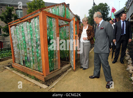 Der Prinz von Wales und Farm Manager Mandy Oliver blicken in ein Gewächshaus aus Plastikflaschen während einer Tour durch die Ouseburn Community Farm in Byker, Newcastle. Stockfoto