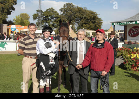 Harriers Call mit Jockey Joseph O'Brien (zweiter links), Trainer John Hayden (links) und Besitzer Mr F. Campbell, nach dem Sieg im Truly Irish Handicap auf dem Irish Field St Leger/Boylesports.com Vincent O'Brien National Stakes Day auf der Curragh Racecourse. Stockfoto