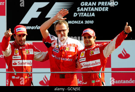 Ferrari's Fernando Alonso (links) aus Spanien feiert seinen Sieg auf dem Podium mit dem drittplatzierten Ferrari Felipe Massa (rechts) und Ferrari's General Director Stefano Domenicali beim Großen Preis von Italien auf dem Monza Circuit, Italien. Stockfoto