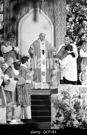 Papst Johannes Paul II. (Mitte) in Begleitung von Kardinal Basil Hume (Hinten links) während der Feier der Messe Stockfoto