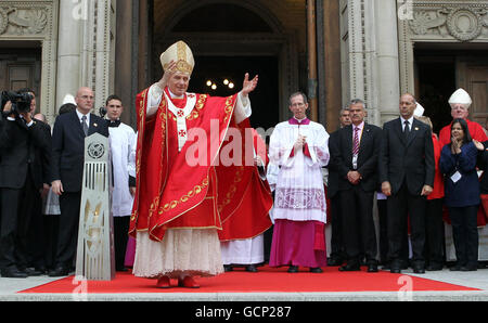 Papst Benedikt XVI. Begrüßt die Menschenmenge, die sich versammelt hat, um ihn zu begrüßen, während er auf den Stufen der Westminster Cathedral im Zentrum von London sitzt, nachdem er die Messe gefeiert hat. Stockfoto