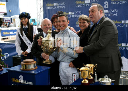 Der Jockey Frankie Dettori und Trainer Dandy Nicholls (links) feiern den Gewinn des William Hill (Ayr) Gold Cup mit Redford, der von dem schottischen Premierminister Alex Salmond überreicht wurde Stockfoto