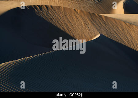Abstrakte Sanddünen mit dunklen Schatten. Stockfoto