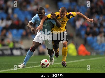 Fußball - UEFA Europa League Finale Qualifikationsrunde - zweite Etappe - Manchester City / FC Timisoara - City of Manchester Stadium. Micah Richards (links) von Manchester City und Alexandru Bourceanu (rechts) von FC Timisoara kämpfen um den Ball. Stockfoto