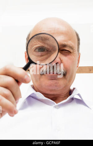 Wissenschaftler der Mann schaut etwas durch ein Vergrößerungsglas Stockfoto