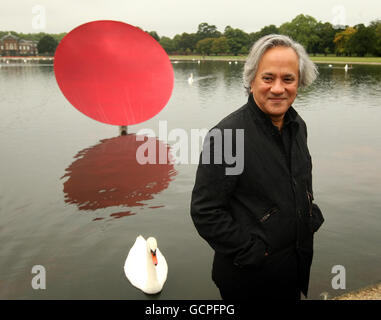 Der Künstler Anish Kapoor ist mit 'Sky Mirror Red 2007' im Rahmen seiner neuen Ausstellung 'Turning the World Upside Down' zu sehen, die bis zum 13. März 2011 vier reflektierende Edelstahlskulpturen in Kensington Gardens im Zentrum Londons umfasst. Stockfoto