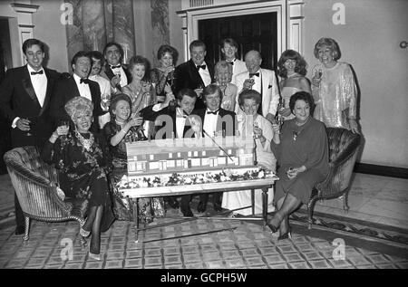 Mitglieder der Besetzung von ITV's Seifenoper Coronation Street drängten sich bei der Feier zum 25-jährigen Bestehen im Dorchester Hotel um eine Kuchennachbildung der Straße. Erste Reihe, von links nach rechts, Julie Goodyear, Eileen Derbyshire, der Serienmaler Tony Warren, William Roache, Jean Alexander und Betty Driver. Hintere Reihe, von links nach rechts, Nigel Pivaro, Johnny Briggs, Michael Le Vell, Bill Tarmey, Thelma Barlow, Anne Kirkbride, Bryan Mosley, Lynn Perry, Kevin Kennedy, Bill Waddington, Helen Worth und Liz Dawn. Stockfoto