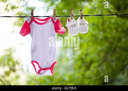 Baby-Kleidung aufhängen auf der Wäscheleine - Familienkonzept Stockfoto