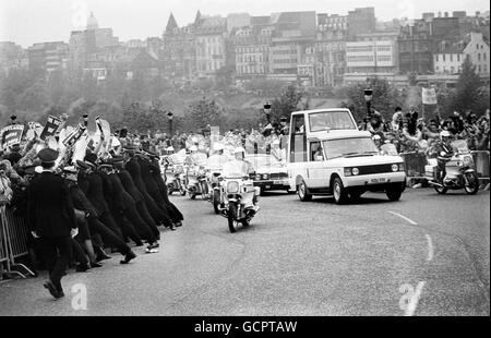 Banner winkende Demonstranten werden von der Polizei zurückgedrängt, als Papst Johannes Paul II., der in seinem „Papemobil“ reitet, sich der Assembly Hall nähert. Stockfoto