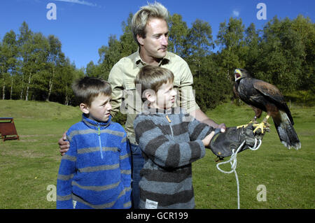 Christopher Foster, 7, (links) und Matthew Foster, 9, aus Stanwick, Northamptonshire, lernen mit Ben Fogle im Forest of Dean, Gloucestershire, Falknerei kennen Stockfoto