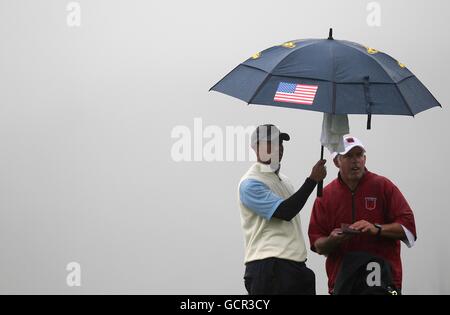 US's Tiger Woods (links) hält den Regenschirm mit Caddy Steve Williams (rechts) während der freitag-Vierball-Runde Stockfoto