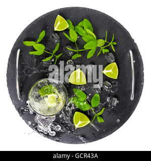 Mojito cocktail mit Splash, Eis, grüne Minze, Heimfahrt Limetten und Tropfen auf Tablett schwarze Schiefer Stein Hintergrund ist isoliert, Nahaufnahme Stockfoto