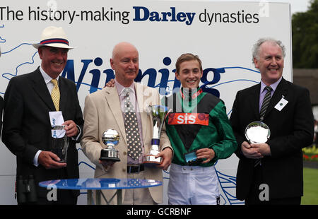 Trainer Henry Candy (links), feiern Besitzer Paul Jacobs (Mitte links), Jockey Harry Bentley (Mitte rechts) und Züchter Seamus nach Limato tagsüber Darley Juli Cup des The Moet & Chandon Juli Festival in Newmarket Racecourse The Darley Juli Cup gewinnt. Stockfoto