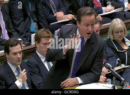 Premierminister David Cameron spricht während der Fragestunde des Premierministers im Londoner Unterhaus, während Bundeskanzler George Osborne (links) und Finanzminister Danny Alexander (zweite links) auf sie schauen. Stockfoto