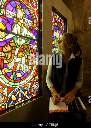 Studentin Holly Roberts studiert eine von vier Buntglasfenstern in der Krypta der Canterbury Cathedral in Kent. Aufgrund umfangreicher Reparaturarbeiten am großen Südfenster der Kathedrale von Canterbury wurden die 800 Jahre alten Glasscheiben, die seit dem 18. Jahrhundert im Fenster stehen, entfernt und während der Reparaturarbeiten gelagert. Etwas, das zwei Jahre dauern kann, um zu vollenden. Stockfoto